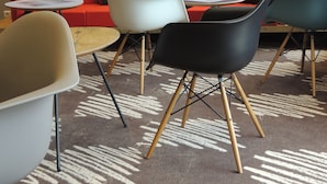A modern lounge area with a red sofa, multiple chairs, and tables. - ibis Auray (Auray)