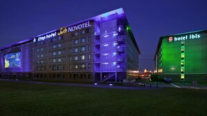 Un hôtel à plusieurs étages, avec une enseigne bien visible indiquant « Etap Hotel Suite Novotel », et une autre enseigne indiquant « hôtel ibis ».