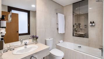Un baño moderno con lavamanos doble, inodoro y bañera.