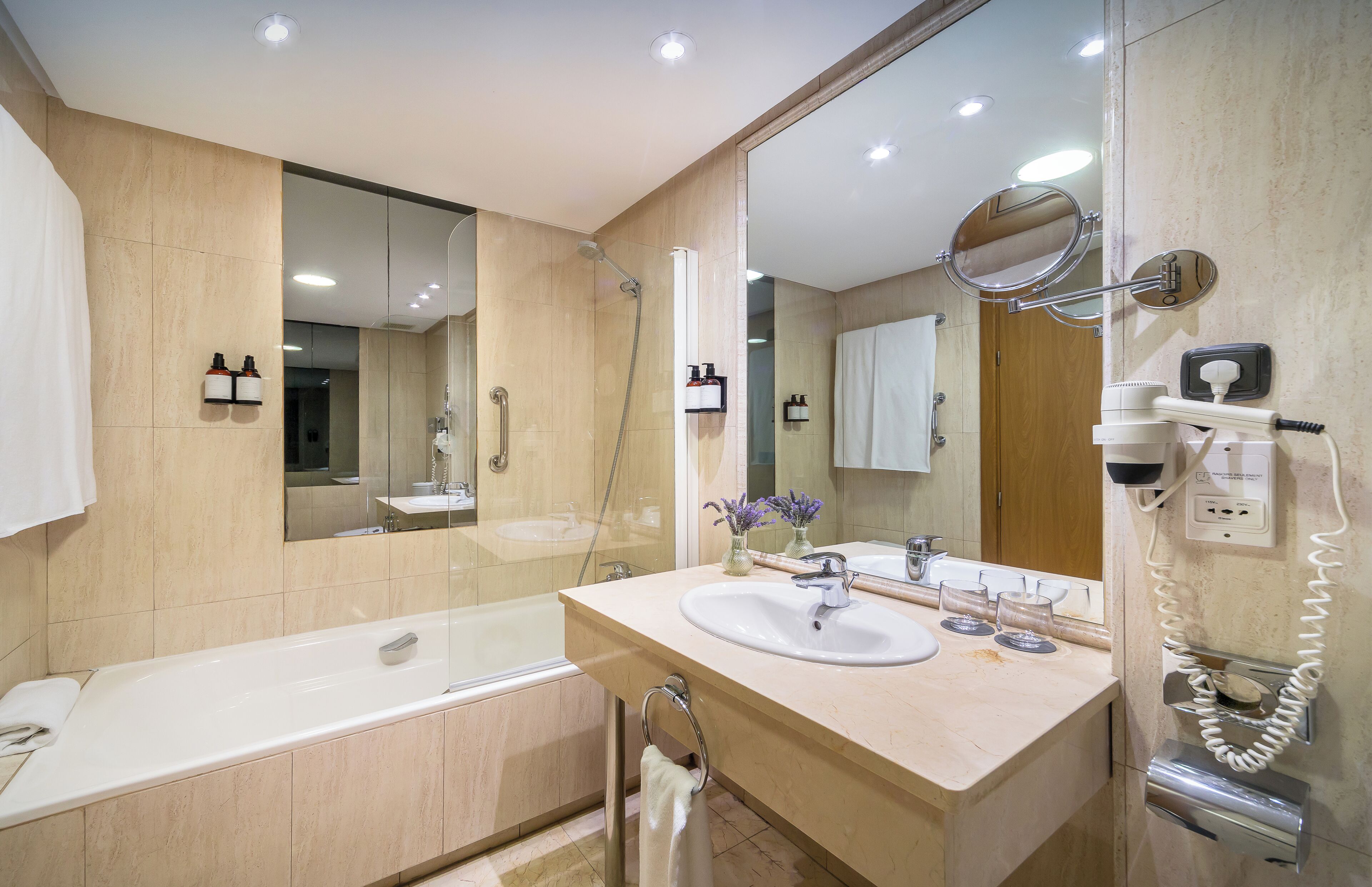 A modern bathroom with a bathtub, a sink, and a mirror.
