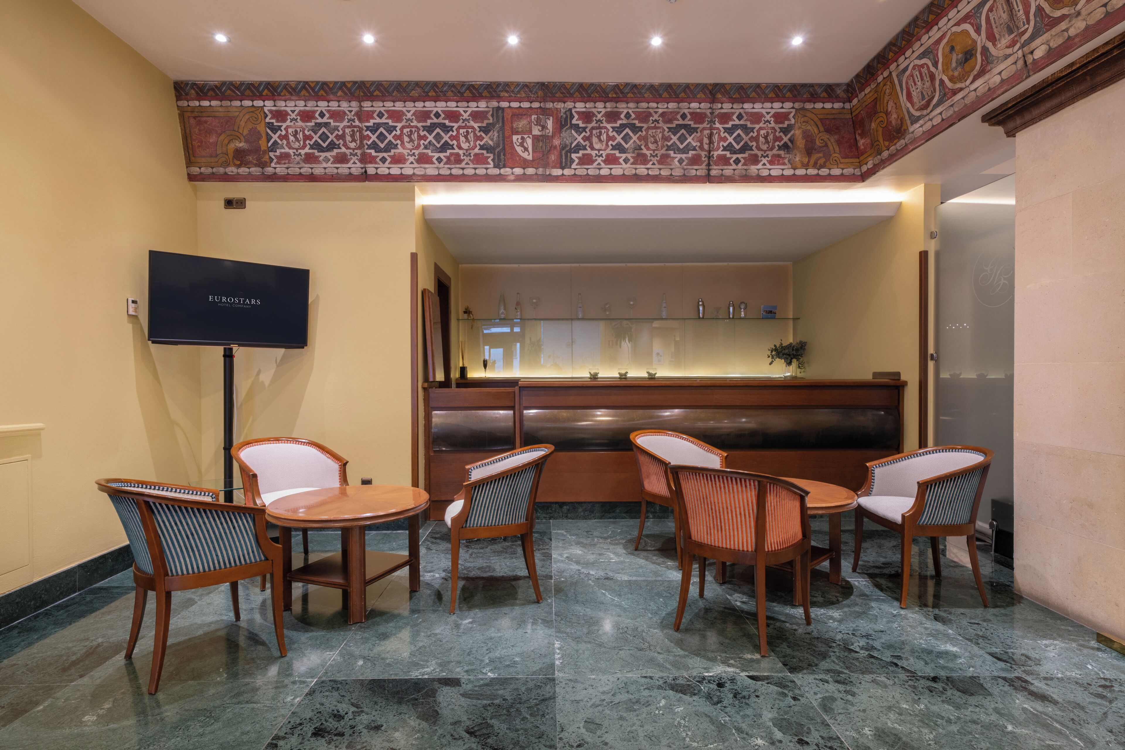 A lobby with a reception desk, seating area, and a television.