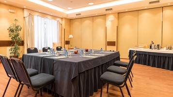 A conference room with a long table, chairs, and a buffet area.
