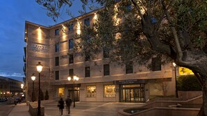 A hotel with multiple floors, a prominent entrance, and a courtyard with a fountain.