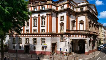 Een historisch gebouw met klassieke architectuur, met een opvallende ingang, meerdere ramen en een hoekligging.