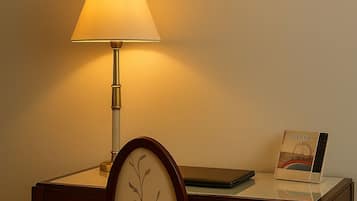 Un escritorio con una lámpara, una silla, un cuadro enmarcado y un libro titulado 'VIENNA' sobre el escritorio.