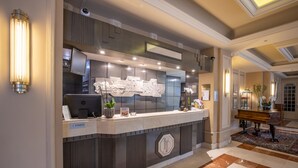 A reception area with a modern design, including a reception desk, a large decorative wall piece, and a piano. - Hotel du Parc - Centre Ville (Mulhouse)