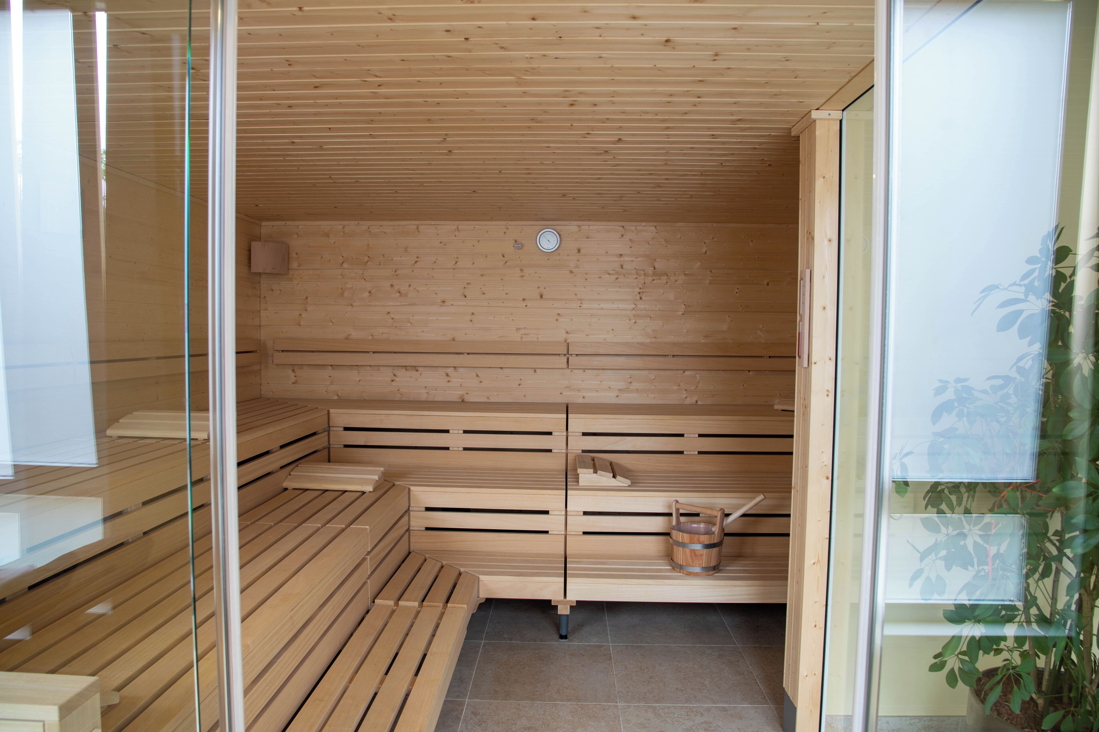A sauna with wooden benches and a wooden wall.