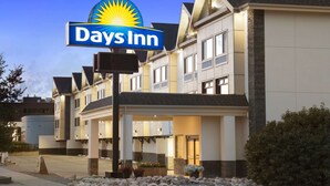Un hôtel Days Inn, reconnaissable à son enseigne bien visible, à ses bâtiments à plusieurs étages et à son entrée bien éclairée.