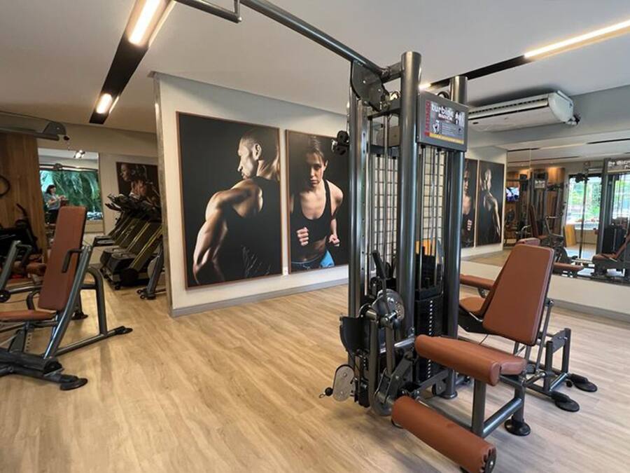 A gym with exercise equipment, wooden flooring, and motivational posters on the walls.