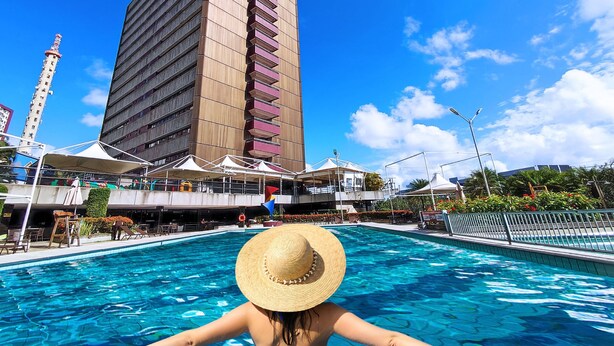 A swimming pool with a high-rise building in the background.