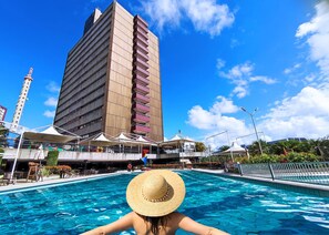 Una piscina con un rascacielos al fondo.