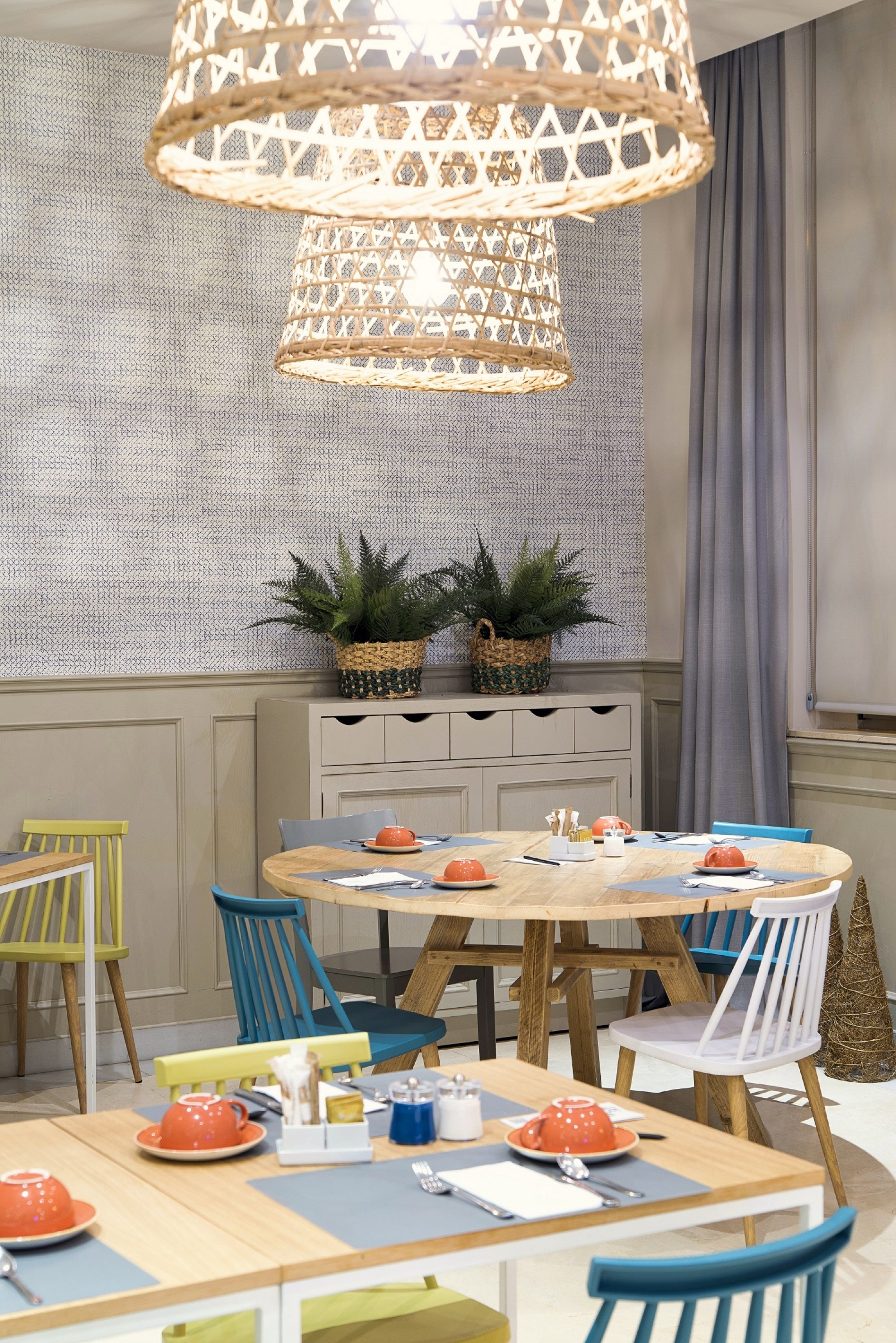 Un espace repas comprenant une table ronde, des chaises et un luminaire suspendu.