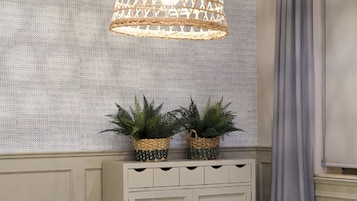 A dining area with a round table, chairs, and a hanging light fixture.