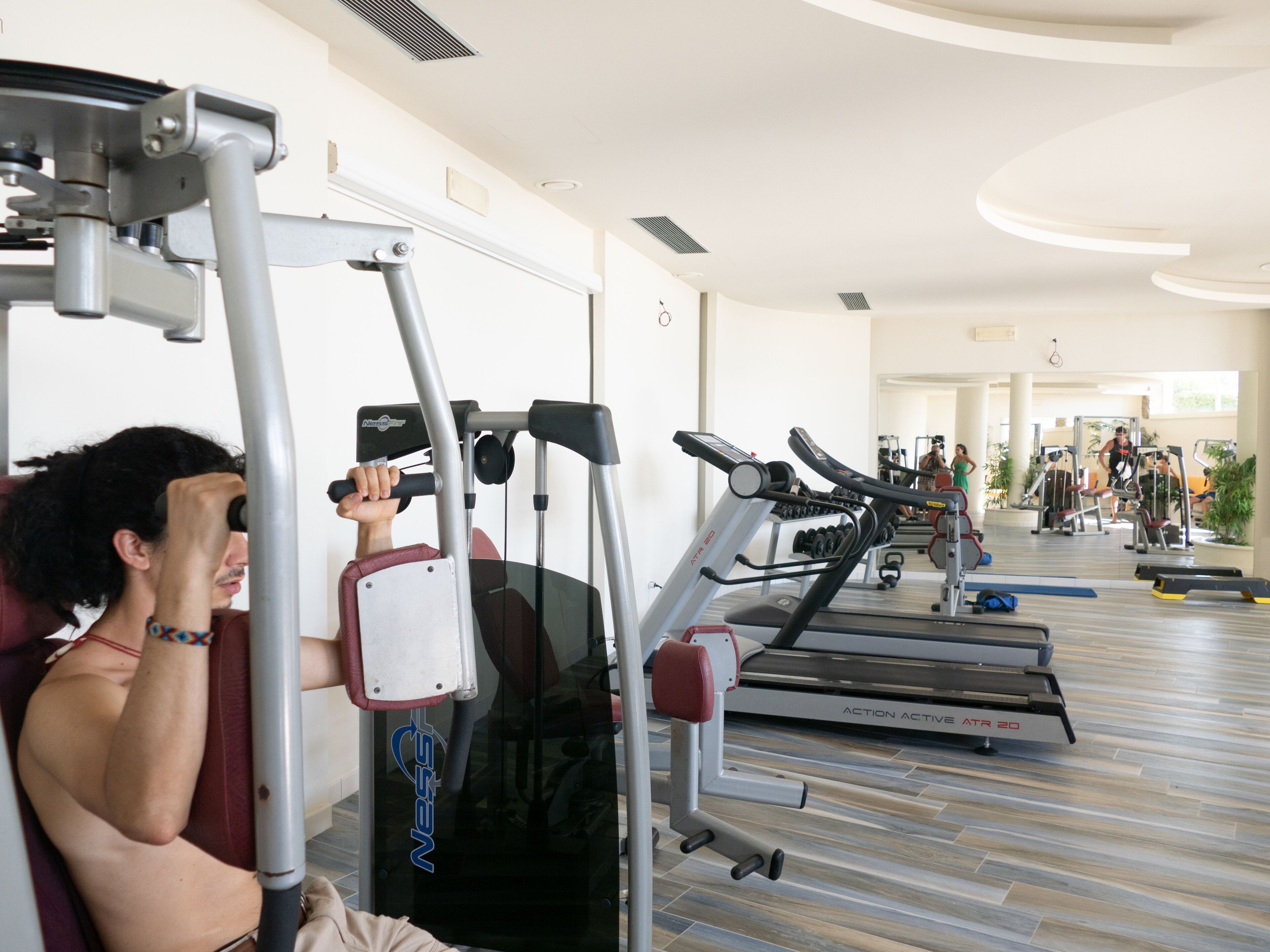 Ein Fitnessstudio mit Trainingsgeräten, darunter Laufbänder und Kraftgeräte.