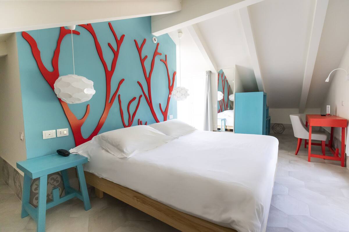 A modern bedroom with a bed, a desk, and a chair.
