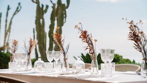 A table set for a meal with clear glassware, candles, and dried plants. - Baia del Sole Resort (Ricadi)