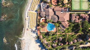 An aerial view of a resort with a beach, a swimming pool, and tennis courts. - Baia del Sole Resort (Ricadi)