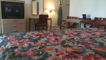Une chambre d’hôtel avec un lit, une télévision, un bureau et une chaise.