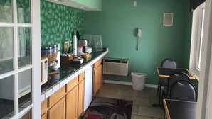 A compact kitchen with a microwave, coffee maker, and a trash bin. - Prestige Inn West Lafayette (West Lafayette)