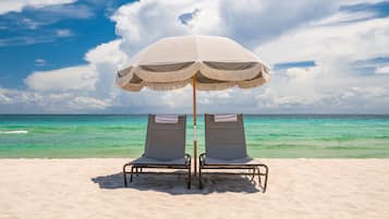 Una playa cerca, sillas reclinables de playa, toallas de playa