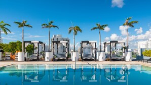 A swimming pool with lounge chairs and palm trees. - Liberty Park Hotel South Beach (Miami Beach)