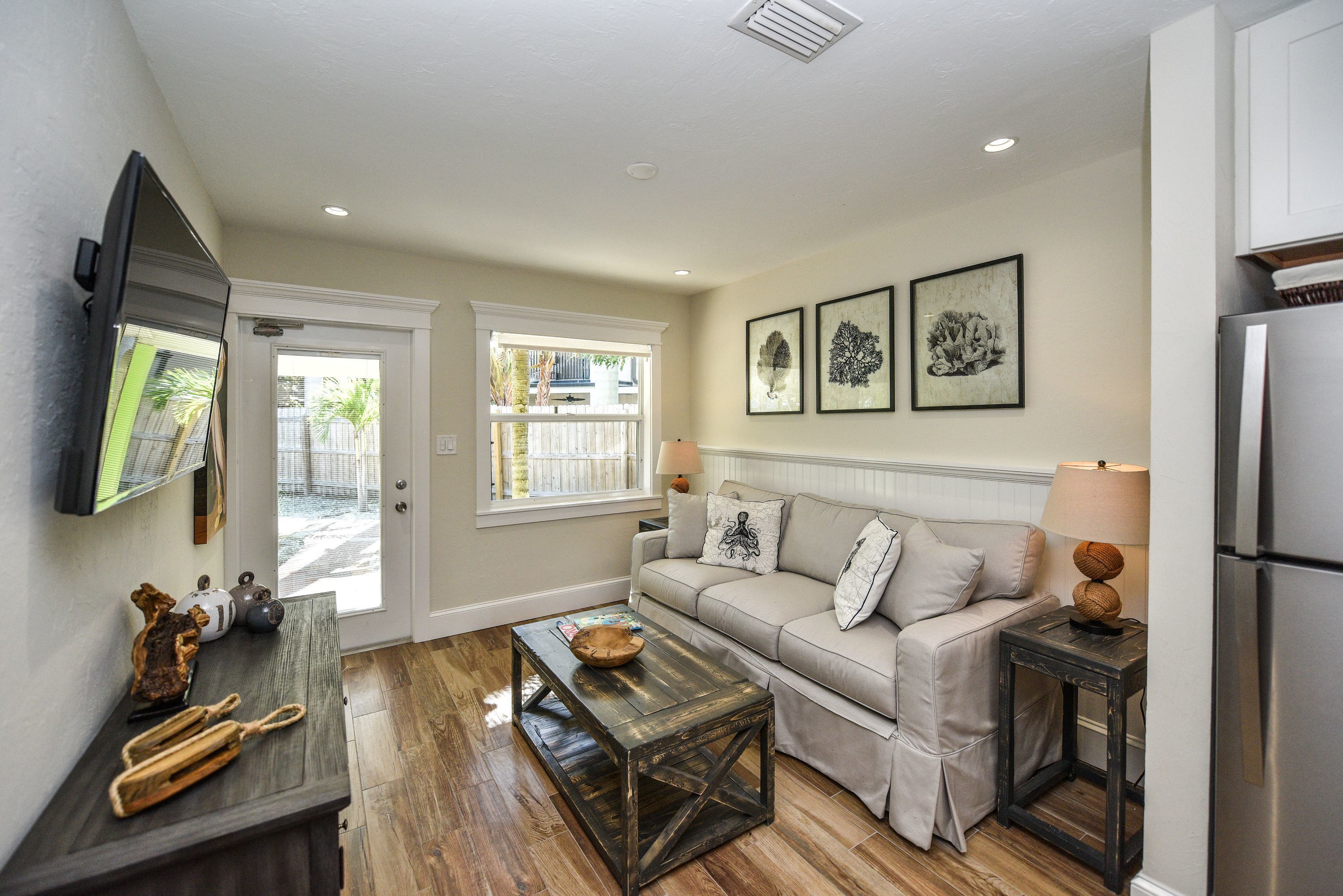 A living room with a sofa, coffee table, and artwork on the wall.