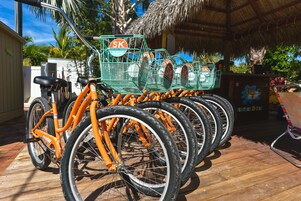 A row of orange bicycles with "SK" branding, parked on a wooden deck.