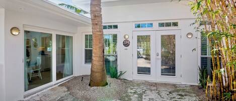 Uma casa moderna com varanda coberta, janelas amplas e placa com o número 114.
