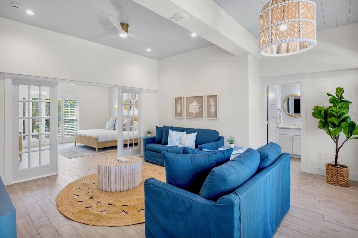 A modern living room with a blue sofa, a round coffee table, and a large window.