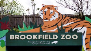 Señal de un zoológico con una ilustración de un tigre y el texto 