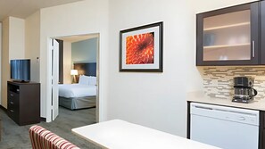 A hotel room with a bed, a desk, a coffee maker, and a framed picture on the wall. - Staybridge Suites Chicago-Oakbrook Terrace by IHG (Villa Park)