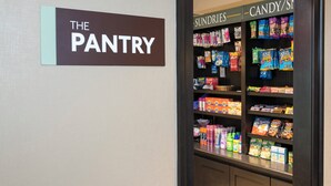 A pantry area with shelves stocked with snacks, beverages, and household items. - Staybridge Suites Chicago-Oakbrook Terrace by IHG (Villa Park)