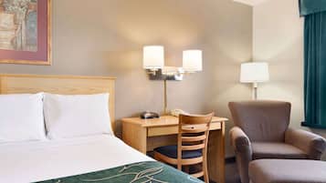 Ein Hotelzimmer mit einem Bett, einem Schreibtisch, einem Sessel und zwei Wandleuchten.