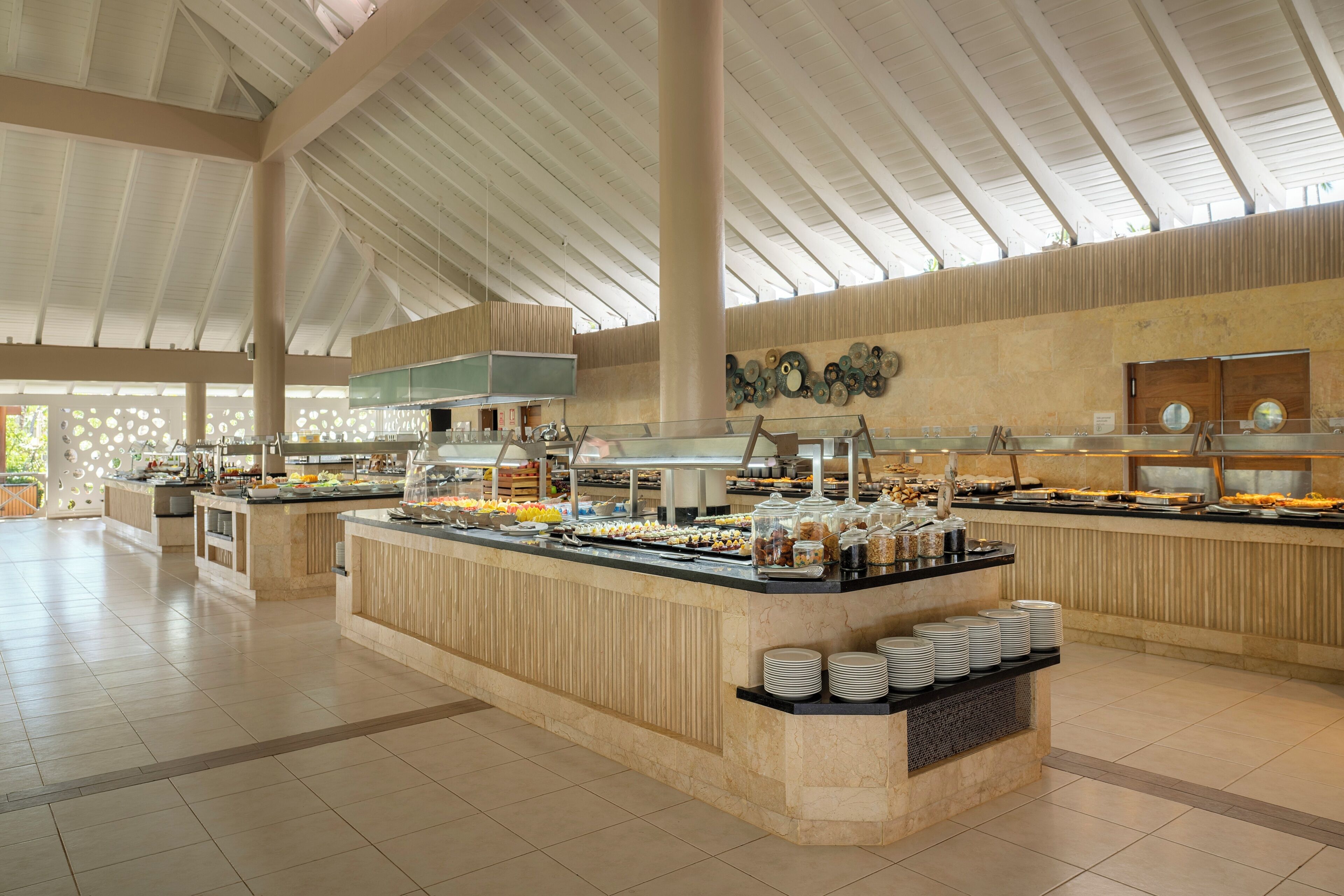 A spacious indoor area with high ceilings and a central buffet counter.