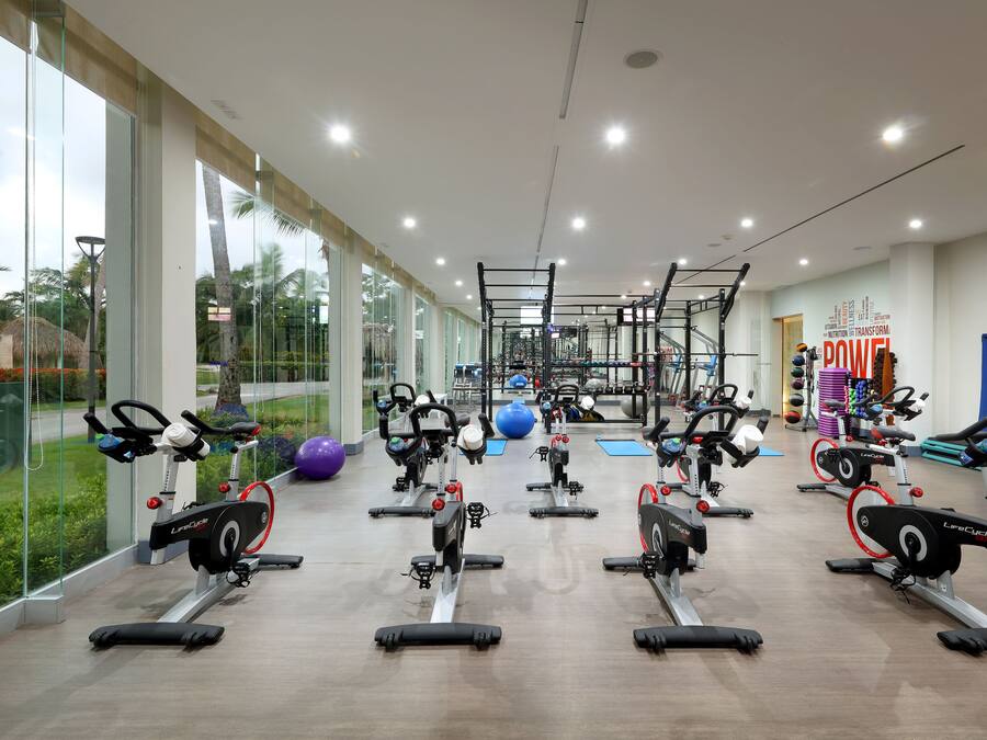 A gym with cardio machines, weightlifting equipment, and exercise balls.