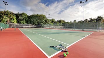 Una cancha de tenis con dos raquetas y tres pelotas.