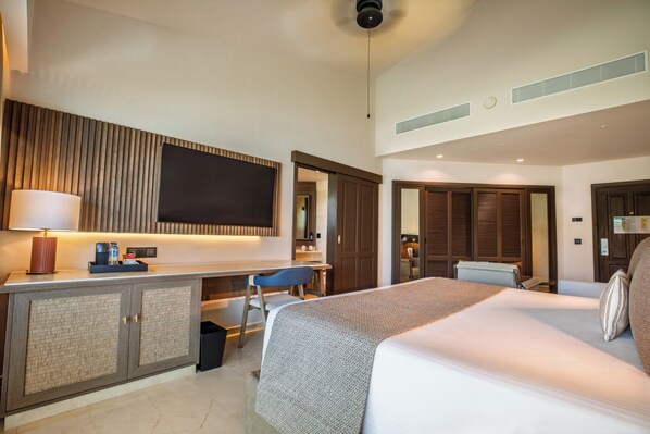 A hotel room with a bed, desk, TV, and wardrobe. - Grand Palladium Select Bávaro - All Inclusive (Punta Cana)