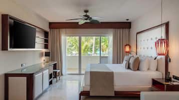 A hotel room with a bed, a TV, a desk, and a balcony with a view.