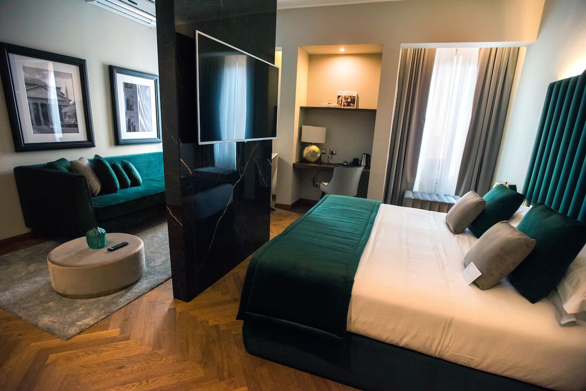 Een hotelkamer met een bed, een bank, een bureau en een televisie.