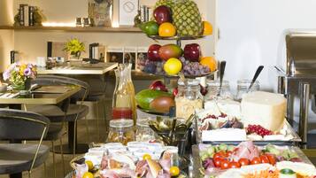 Una mesa de buffet con diferentes alimentos y una exposición de frutas.