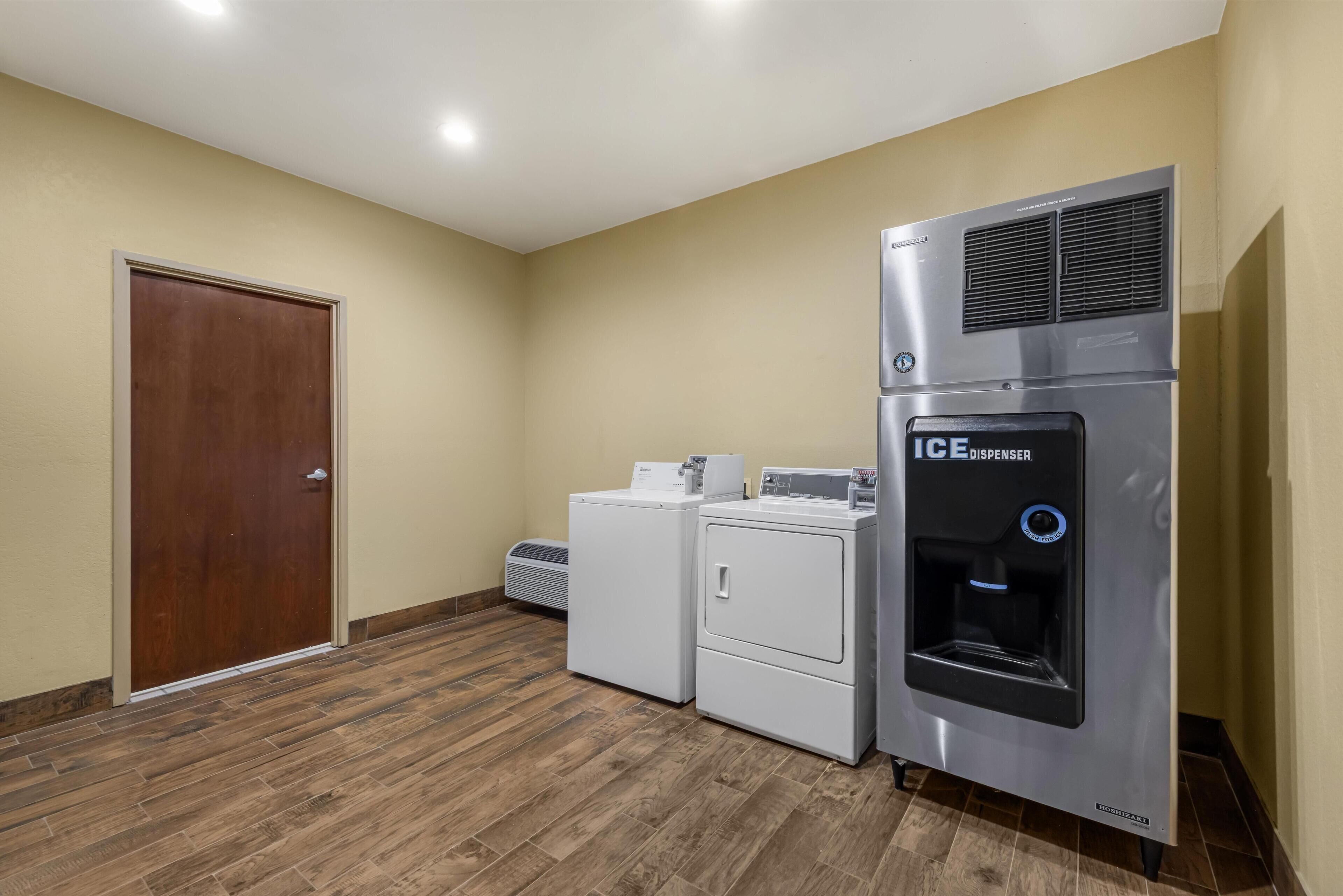 A laundry room with a washing machine, dryer, and an ice dispenser.