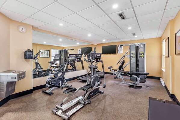 A gym with various exercise equipment, including treadmills, elliptical machines, and weight machines. - Best Western Plus Executive Inn (Toronto)