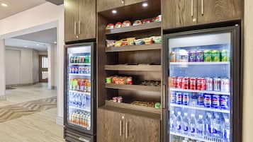 A vending machine area with multiple beverage options including sodas, snacks, and bottled water.