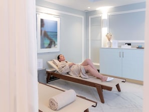 A spa room with a reclining chair, a window with a view, a cabinet, and a towel on the floor. - The 1932 Hotel & Spa Cap d'Antibes - MGallery Collection (Antibes)