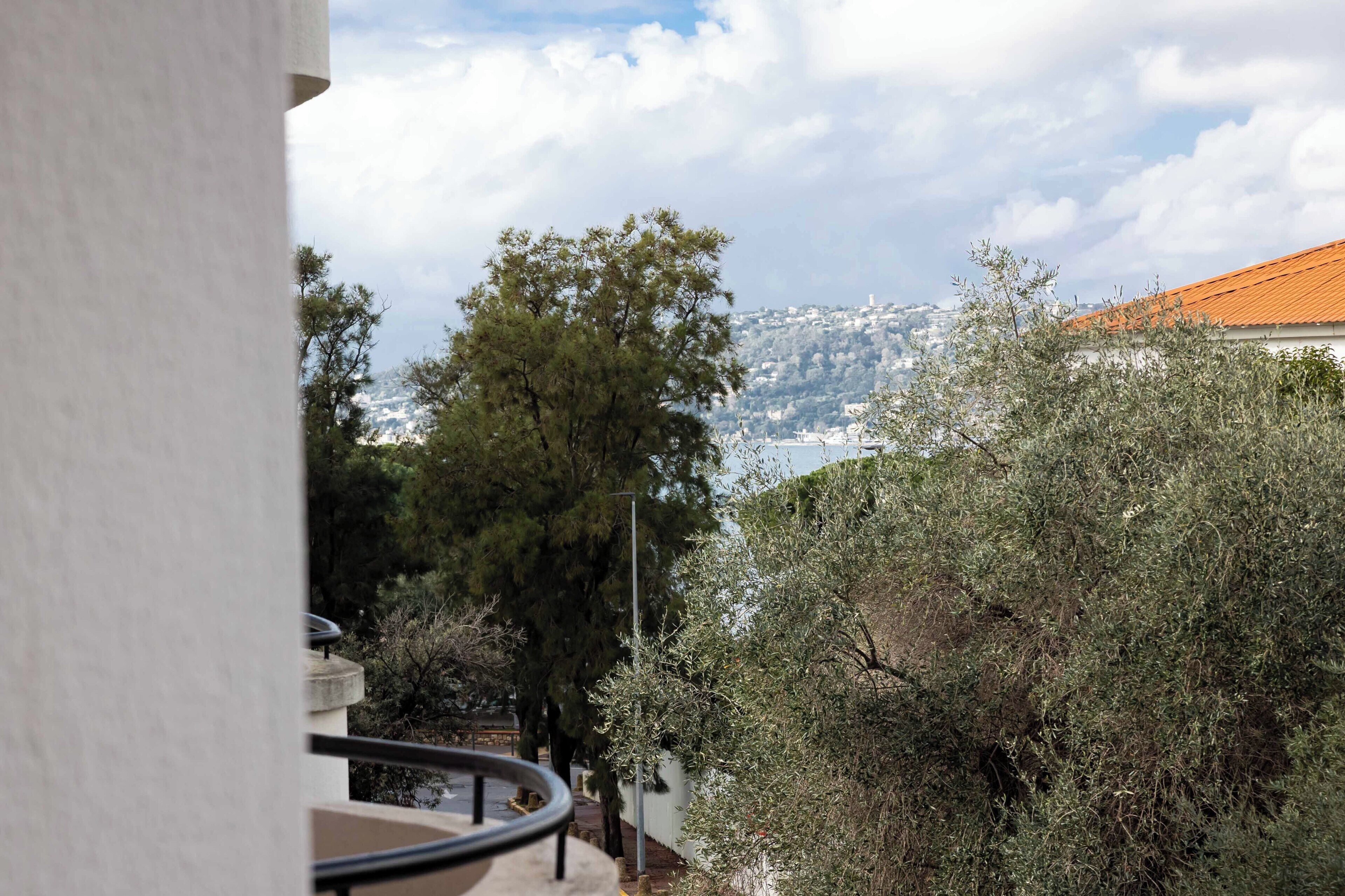 A balcony with a view of a mountain and trees.