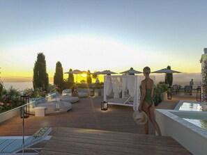 Una piscina al aire libre, sombrillas, sillones reclinables de piscina