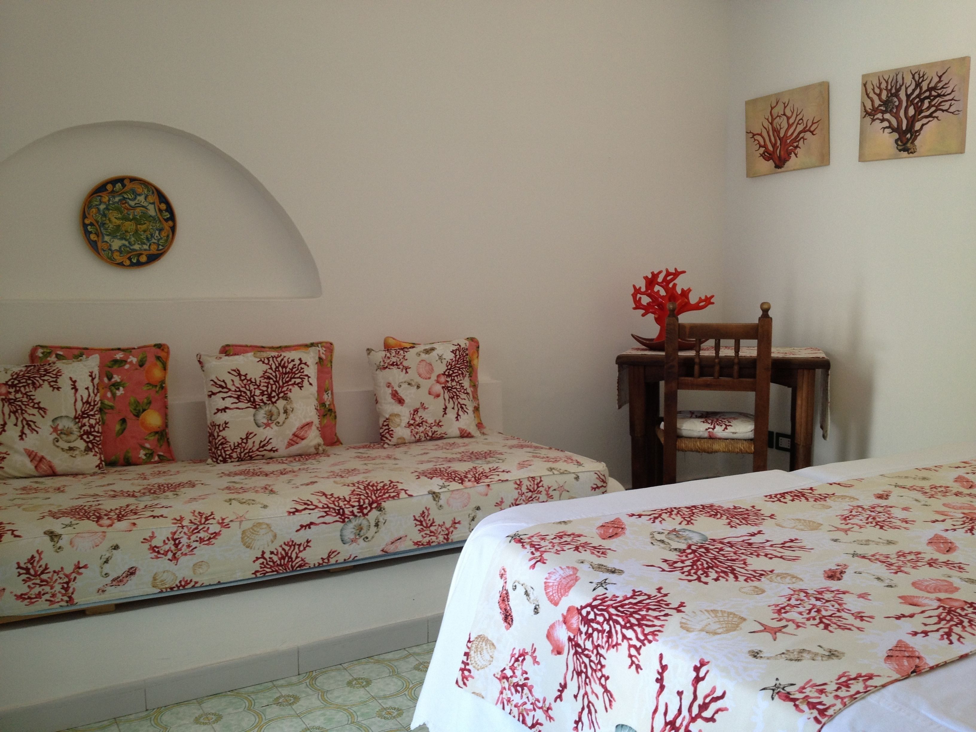 A bedroom with two beds, a chair, and a wall-mounted decoration.