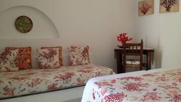 A bedroom with two beds, a chair, and a wall-mounted decoration.