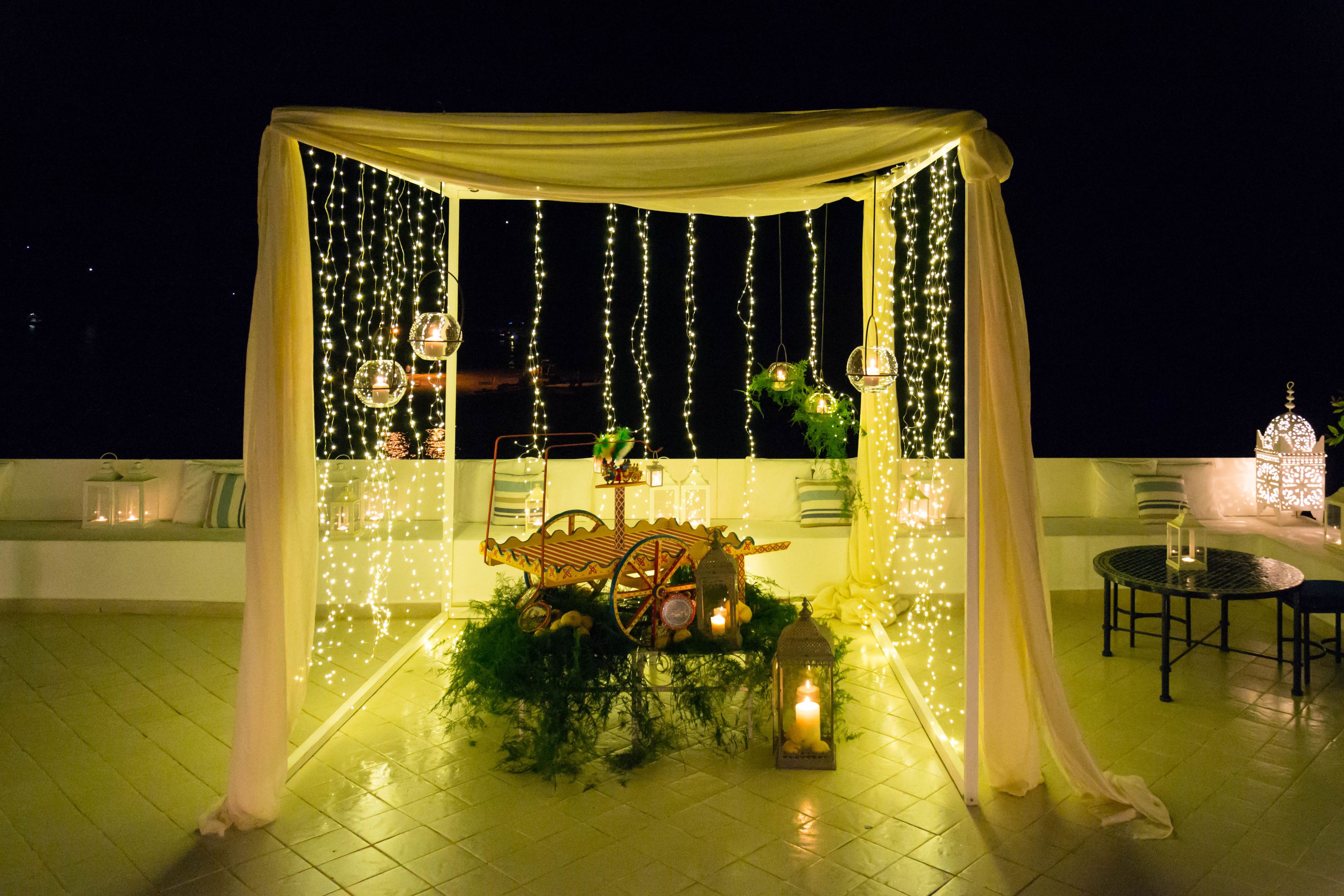 Une cérémonie de mariage en plein air, avec un auvent, des guirlandes lumineuses et un chariot décoratif.