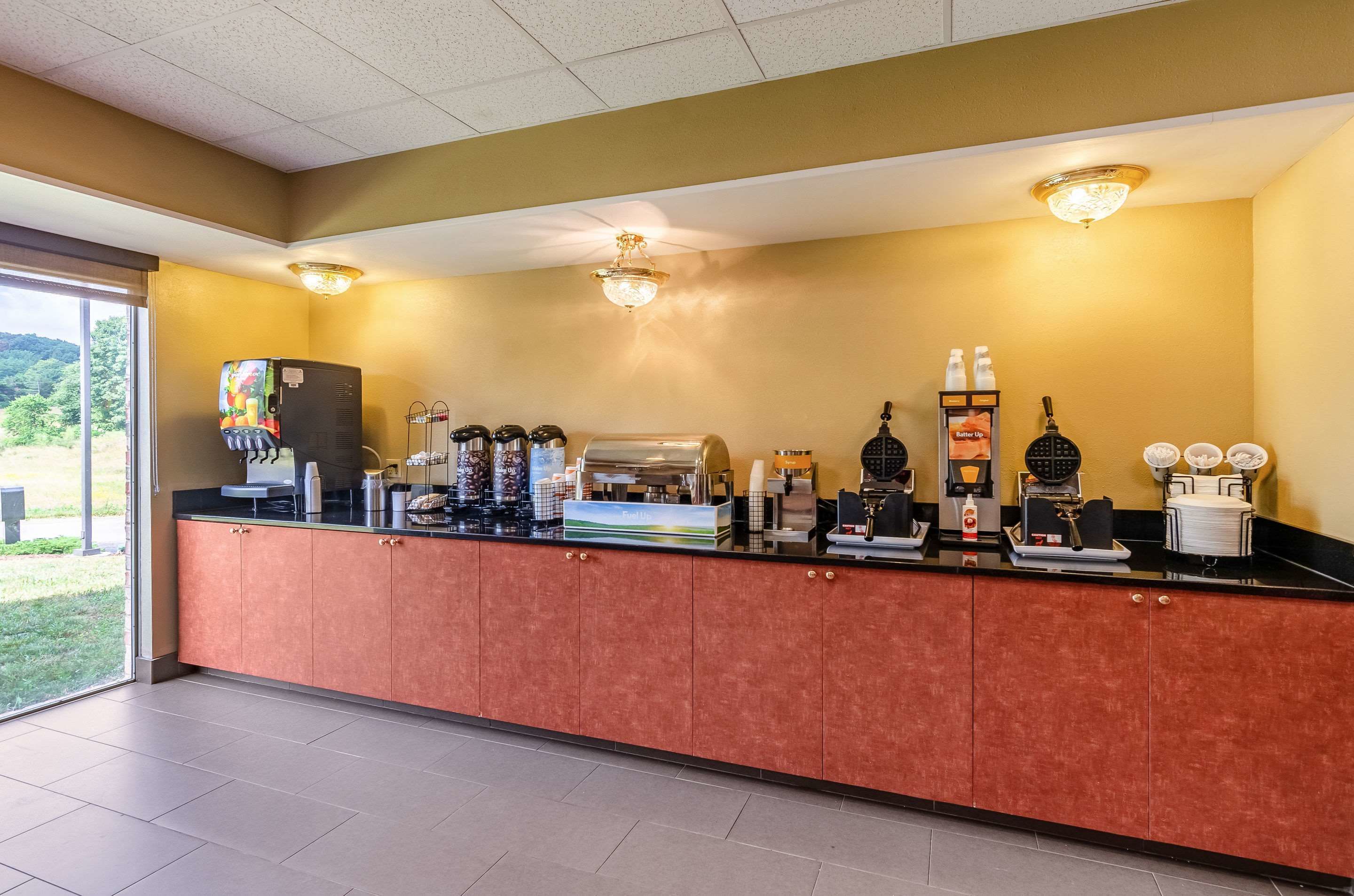 A reception area with a counter, coffee machines, and a view of the outdoors.